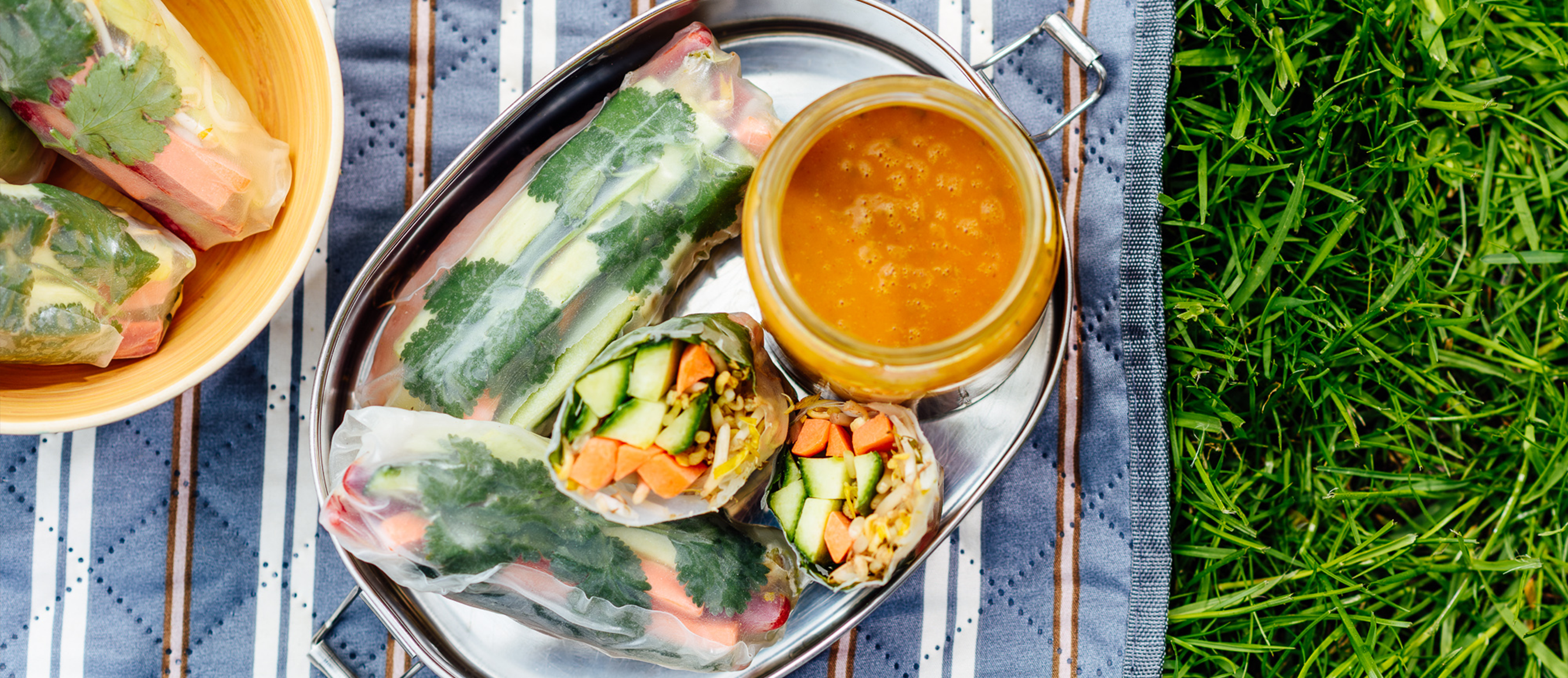 Sommerrollen auf einem Metalltablett serviert, daneben eine sauce