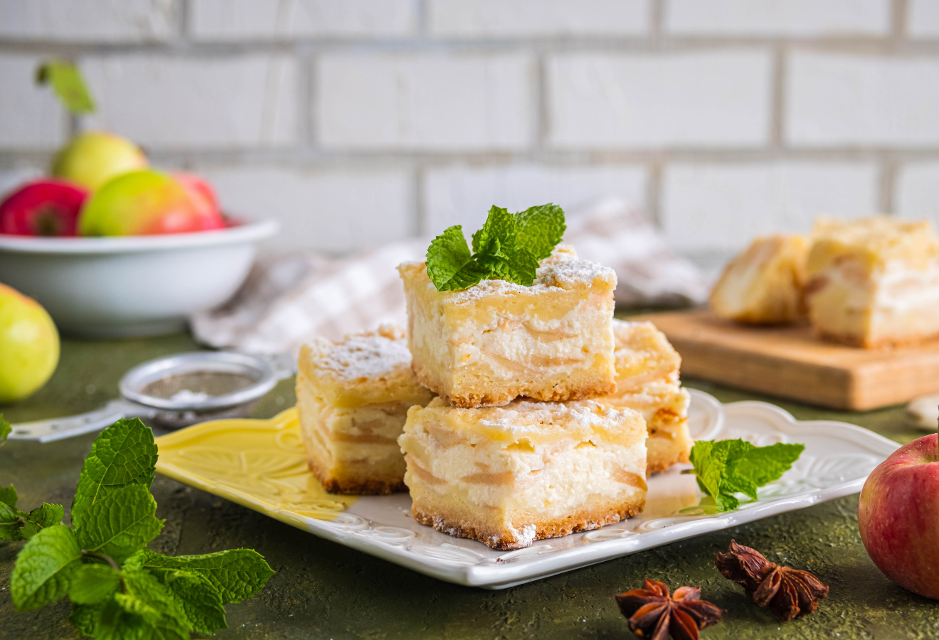 Apfel-Karamell-Käsekuchen auf einem Teller angerichtet, mit frischen Minzblättern